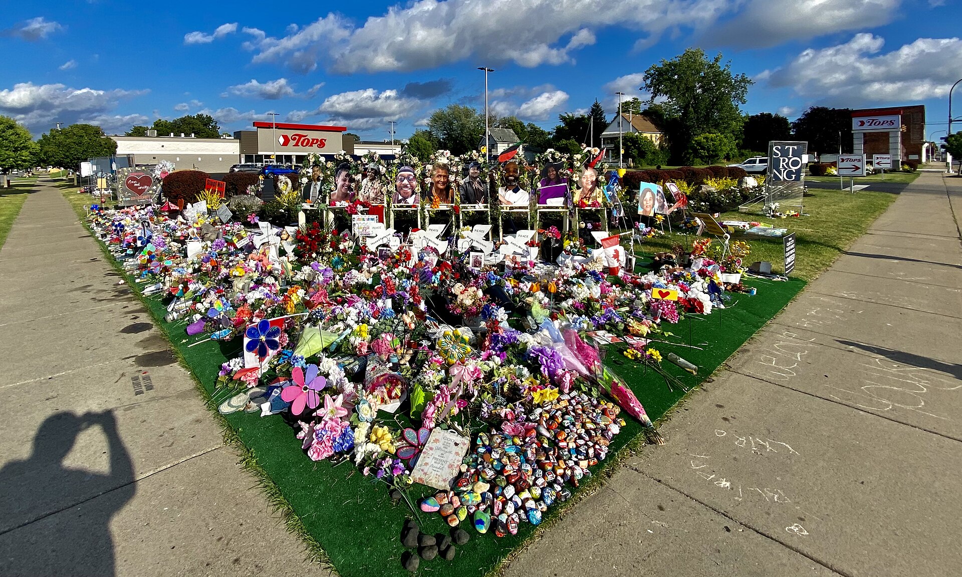 Wide view of community tributes at the Jefferson Avenue and Landon Street memorial beside the Tops supermarket in July 2022