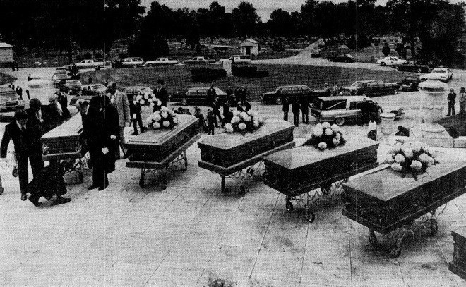 Nine flower-topped coffins arranged outside a chapel during the June 1981 memorial service for Gacy victims who remained unidentified