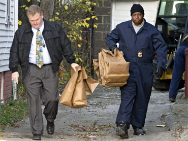 Cleveland police carrying evidence bags from the property beside Sowell's Imperial Avenue home on November 11, 2009